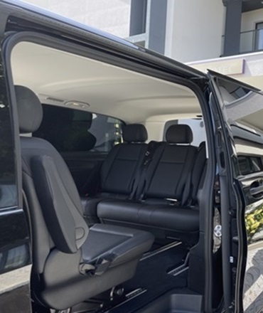 ransport VIP Mercedes Classe V | KDriver Corse Luxe & Yachts Intérieur en cuir noir d'un van Mercedes Classe V, porte ouverte en attente des clients d'un hôtel en Corse, service de transport VIP KDriver Corse.
