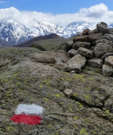 Sentier GR20 Vizzavona | Transport GR20 Sud avec KDriver Corse Sentier du GR20 à Vizzavona avec marquage rouge et blanc, montagnes enneigées en arrière-plan, pour un transport GR20 KDriver Corse.